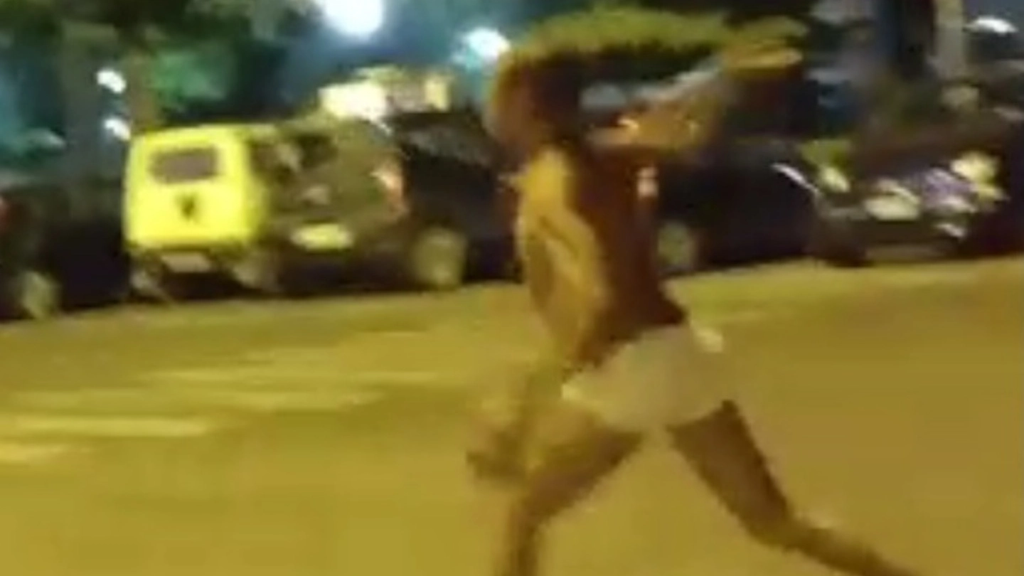 Il giovane africano mentre lancia sassi in piazza Tasso