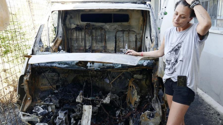 La presidente di Stremao Francesca Squilloni accanto al furgone incendiato (foto Attalmi)