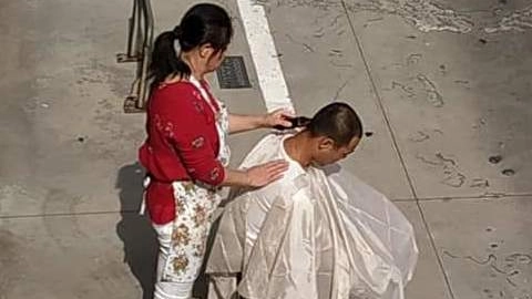 Sedia in strada: il barbiere taglia alla luce del sole