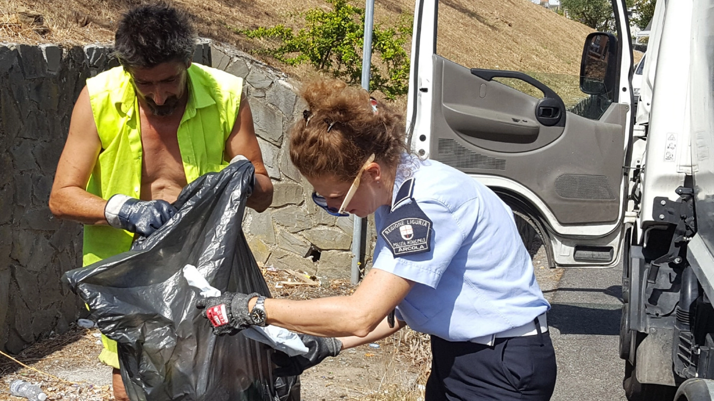 Un’agente della municipale e un operatore Acam cercano indizi degli incivili tra i rifiuti abbandonati