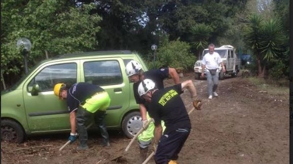 Volontari tolgono il fango da una strada dopo una frana (foto di repertorio)