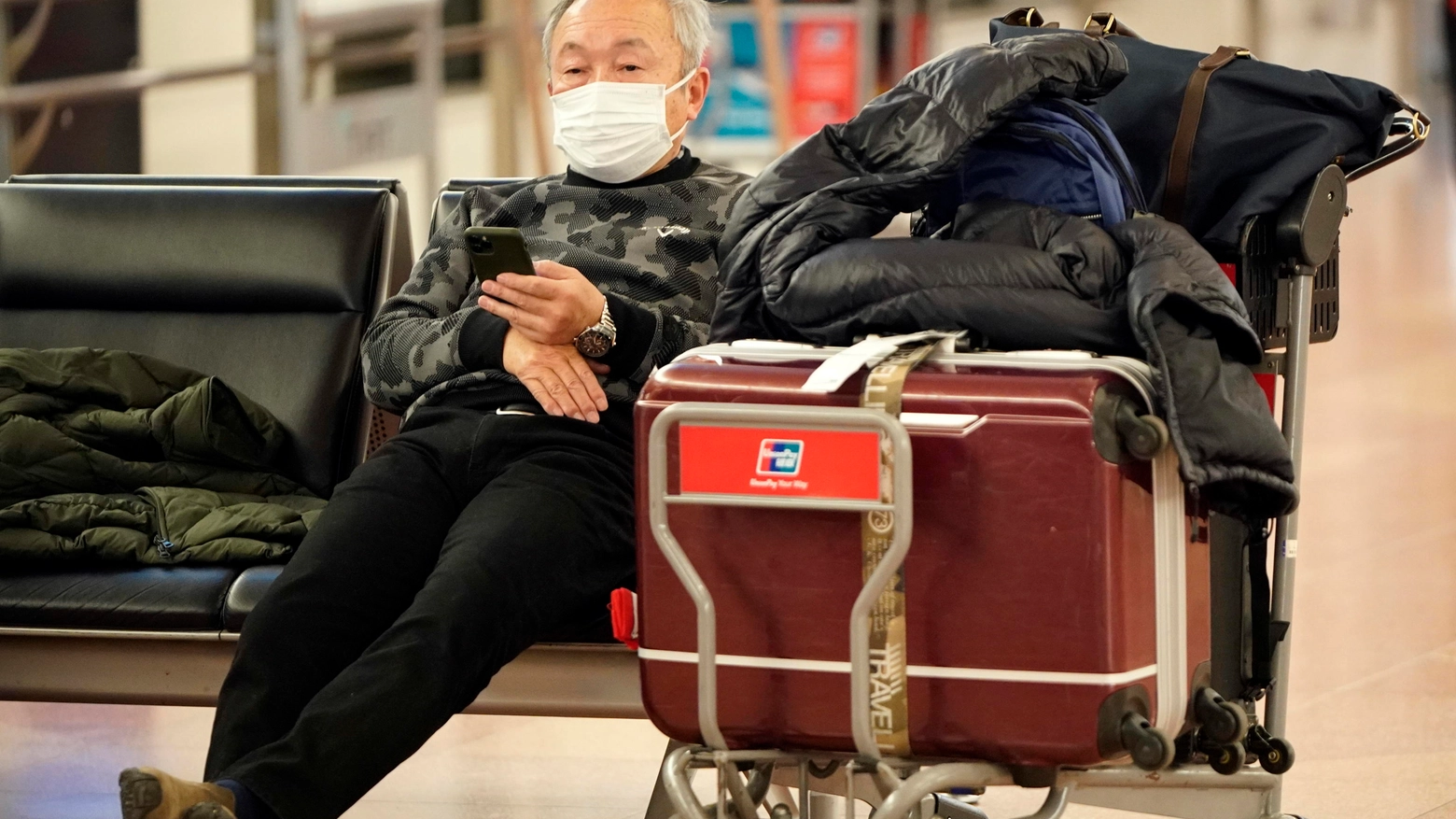 Viaggiatore con la mascherina in un aeroporto orientale  