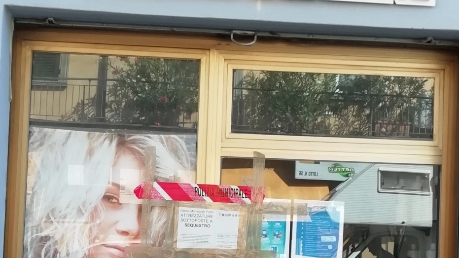 L'ingresso del negozio di parrucchiere coi sigilli di sequestro