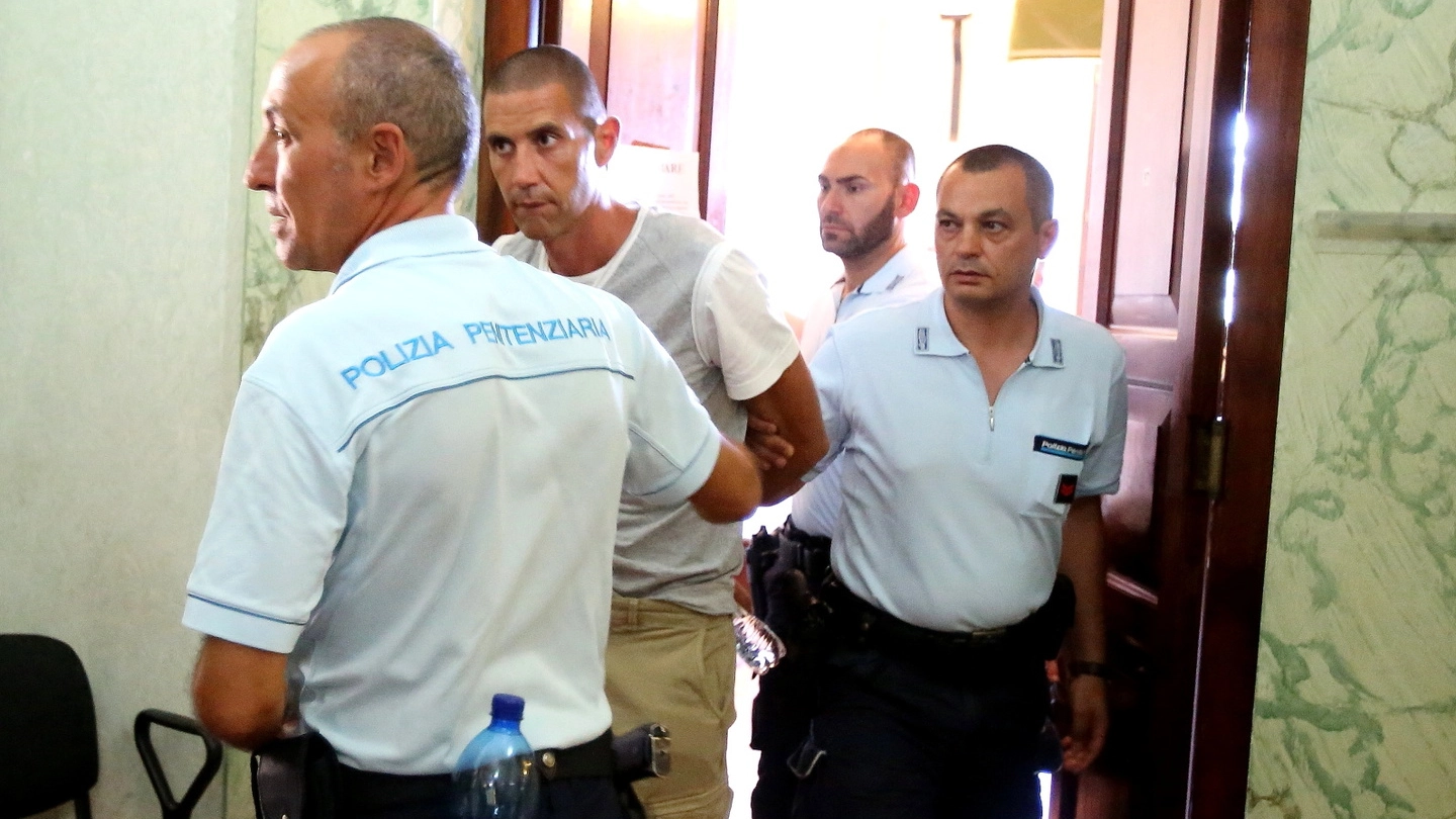 Emanuele Armeni scortato dalla polizia penitenziaria esce dall’aula del tribunale di Spoleto