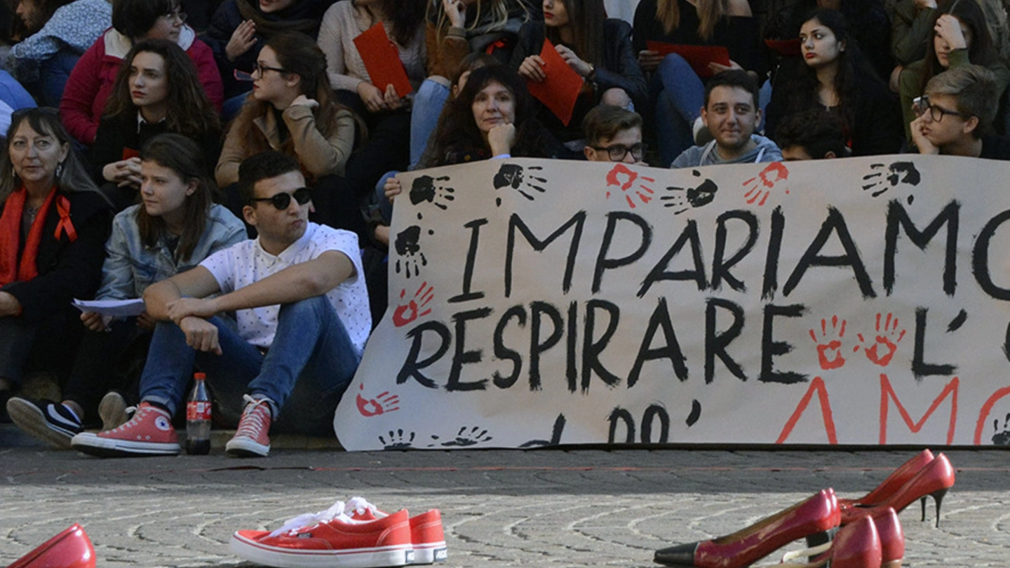 Il momento in cui sono state sistemate in piazza Dante le scarpe rosse diventate simbolo della lotta al femminicidio (Foto Aprili)