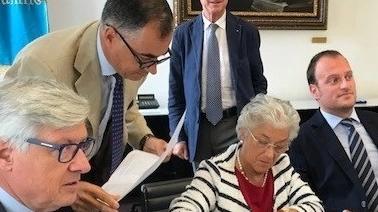 Giuseppina Micheletti mentre sottoscrive il contratto davanti al notaio nella sede della Fondazione Cassa