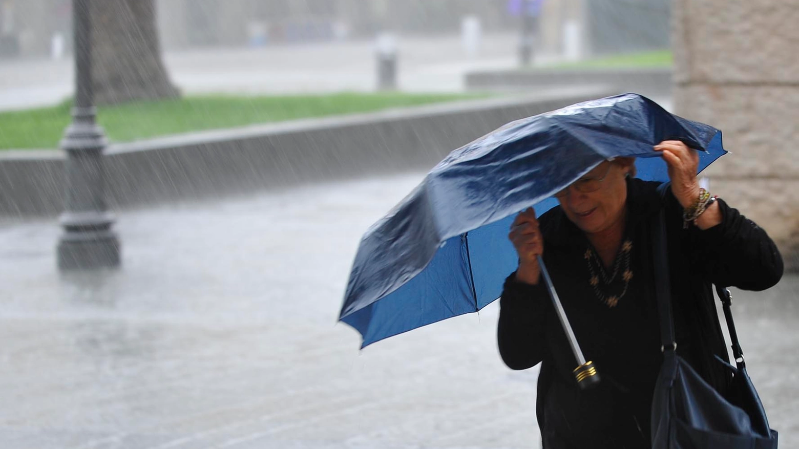 Una donna si ripara dalla pioggia a Livorno nella mattinata del 1 ottobre (Foto Novi)