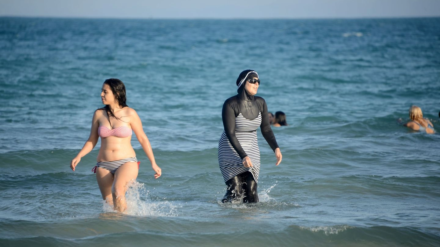 Una donna tunisina in spiaggia con il burkini (Afp)
