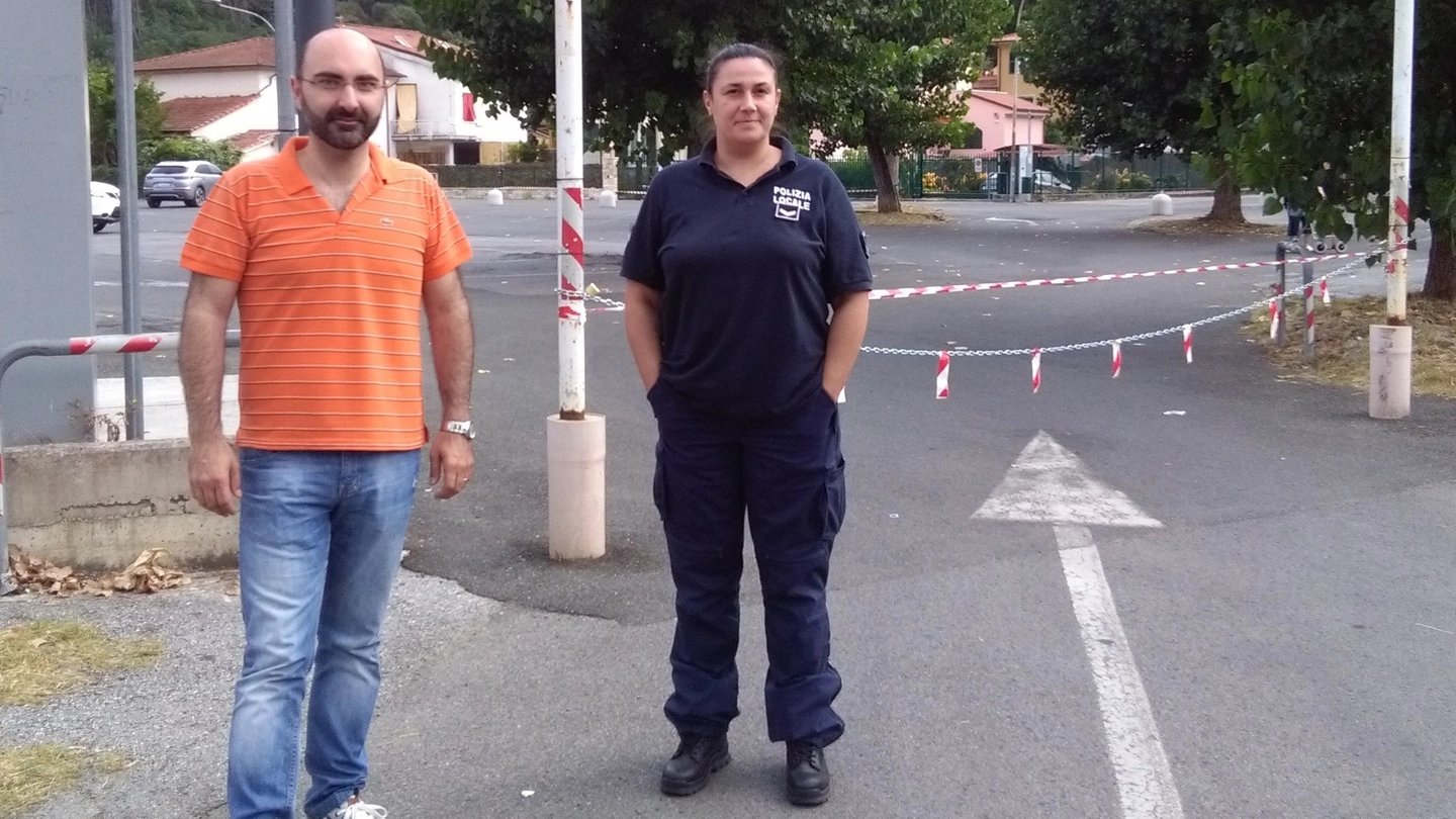 Il sindaco di Ameglia Andrea De Ranieri davanti al parcheggio chiuso con le catene con un agente della polizia municipale