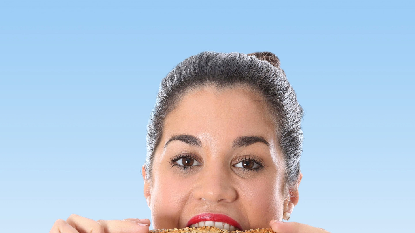Una donna mangia un sandwich in una foto generica di repertorio