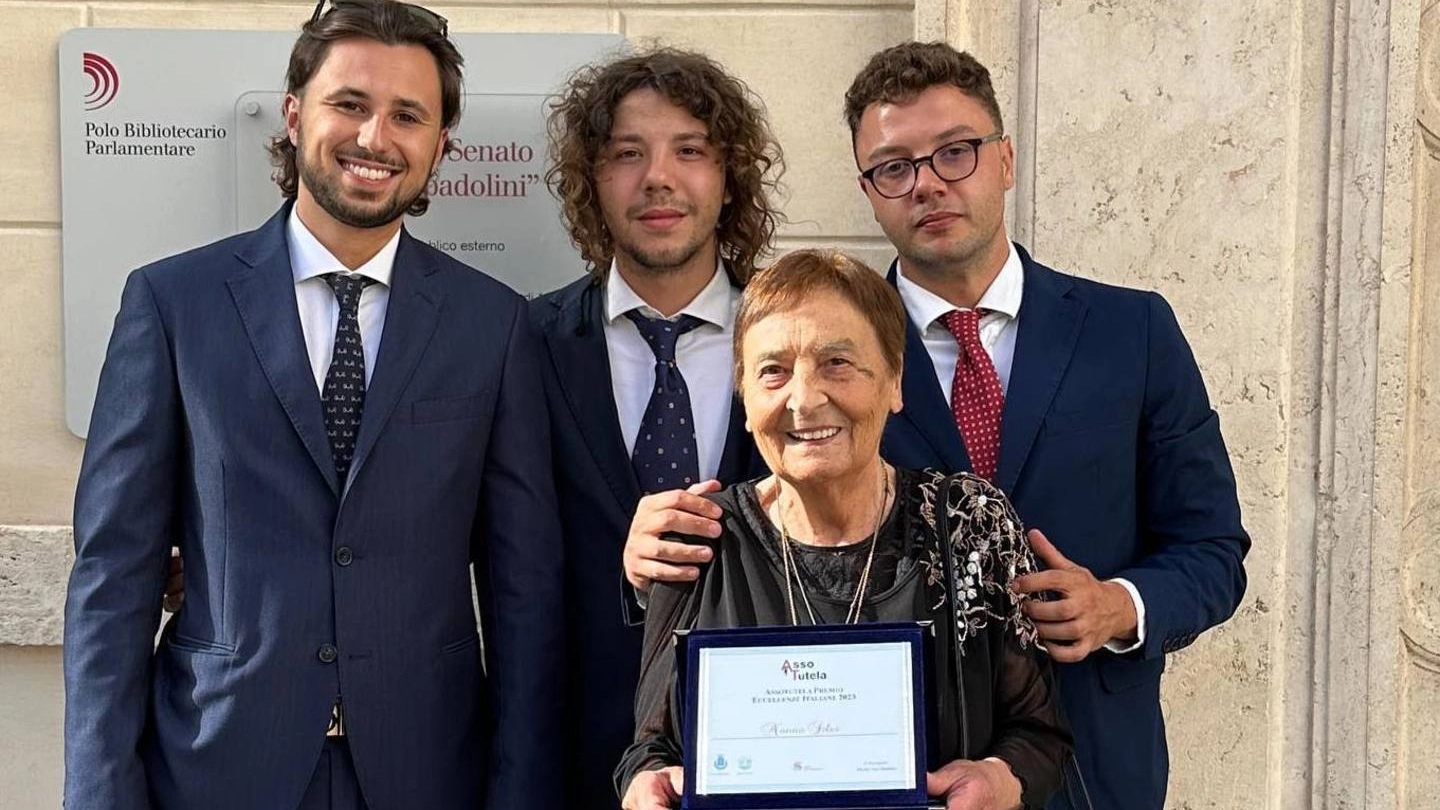 Nonna Silvi sfoggia la targa ricevuta nella sala capitolare della biblioteca del Senato