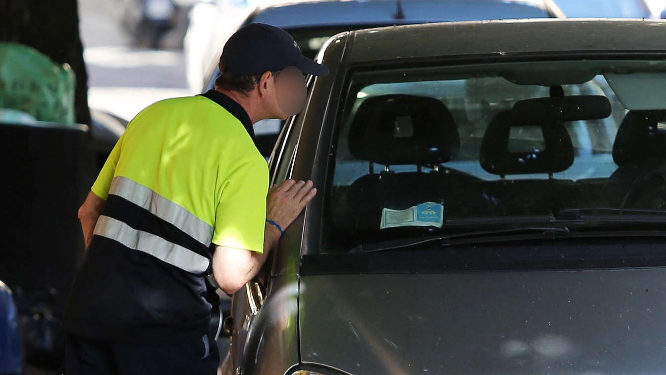 Un operatore Sipa intento a verificare la regolarità del parcheggio di una vettura