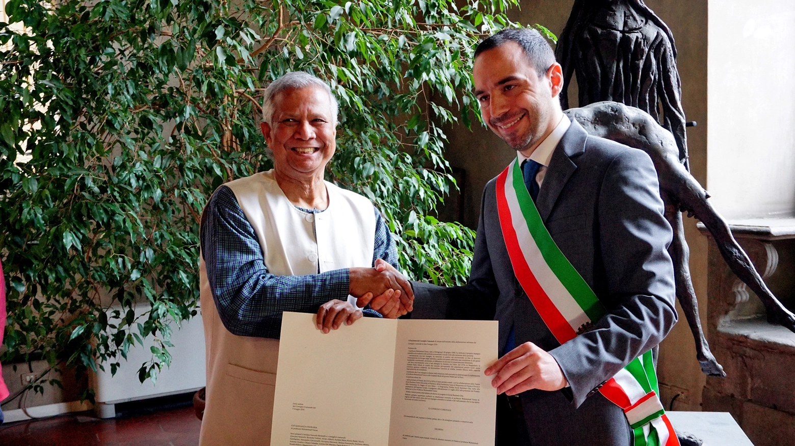La stretta di mano tra il sindaco Bertinelli e Muhammad Yunus (Foto Castellani)