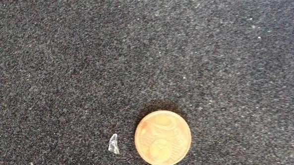 La scheggia di vetro accanto a una moneta da 2 centesimi