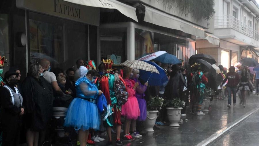 Maschere e ospiti del Carnevale si riparano dalla pioggia