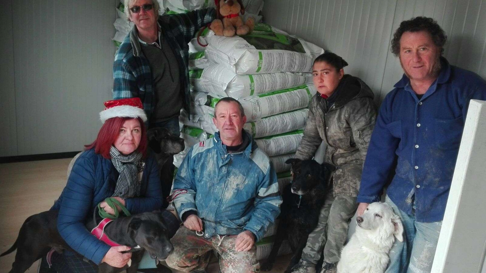 I volontari del canile di Ossaia con alle spalle le crocchette donate da Jovanotti
