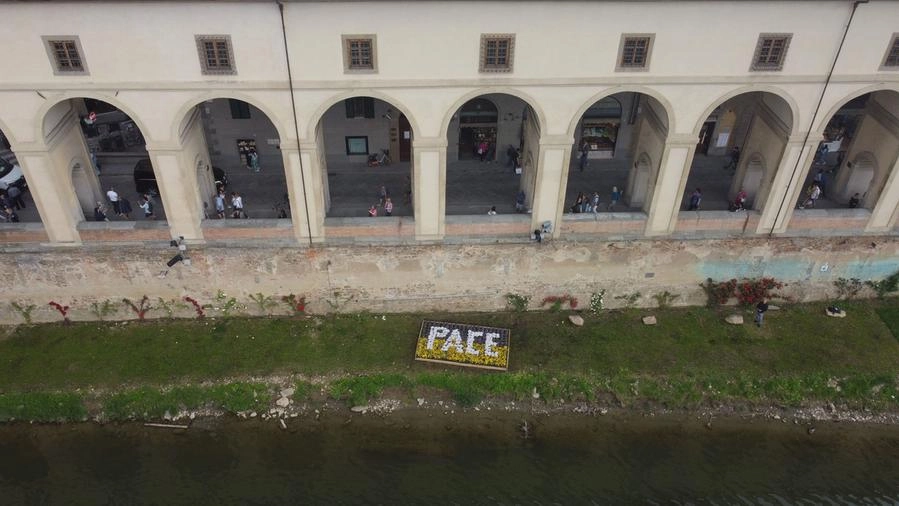 La scritta "Pace" sulla riva dell'Arno (New Press Photo)