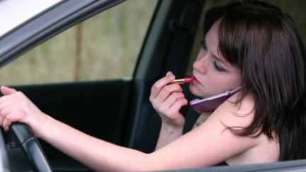 Una ragazza che parla al telefono mentre è alla guida 