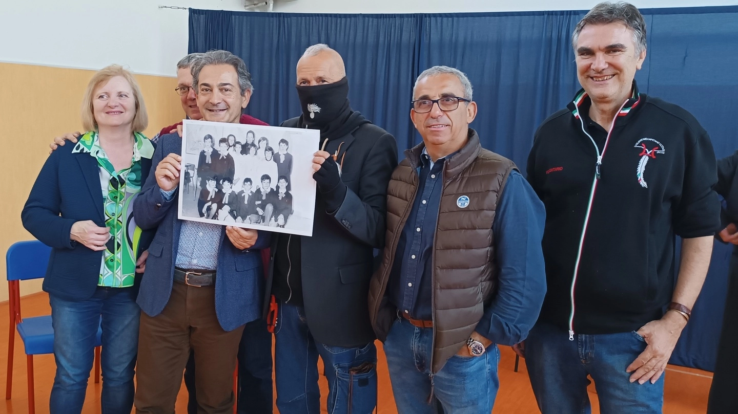 Il Capitano Ultimo insieme ad alcuni suoi ex compagni di scuola a Braccagni mostra la foto di classe