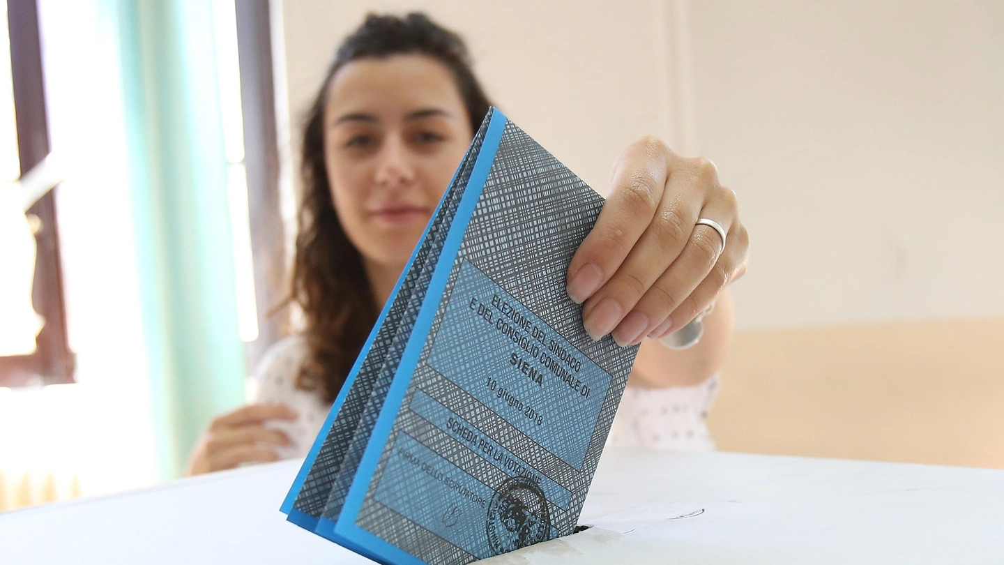 Una votante imbuca la scheda nell'urna