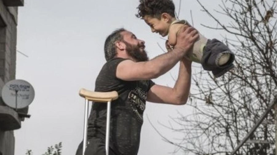 Ha fatto il giro del mondo la foto del papà con la stampella che solleva Mustafa, 6 anni