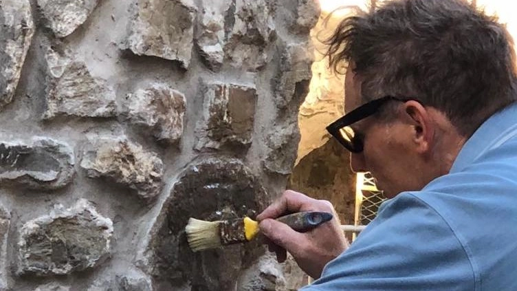Tecnici dell’Accademia di Carrara preparano il calco sostitutivo dell’antica stele inserita nel muro esterno di una casa