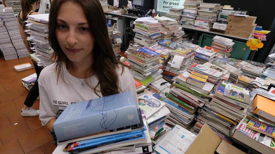 Una ragazza con i libri per il nuovo anno scolastico (foto di archivio)