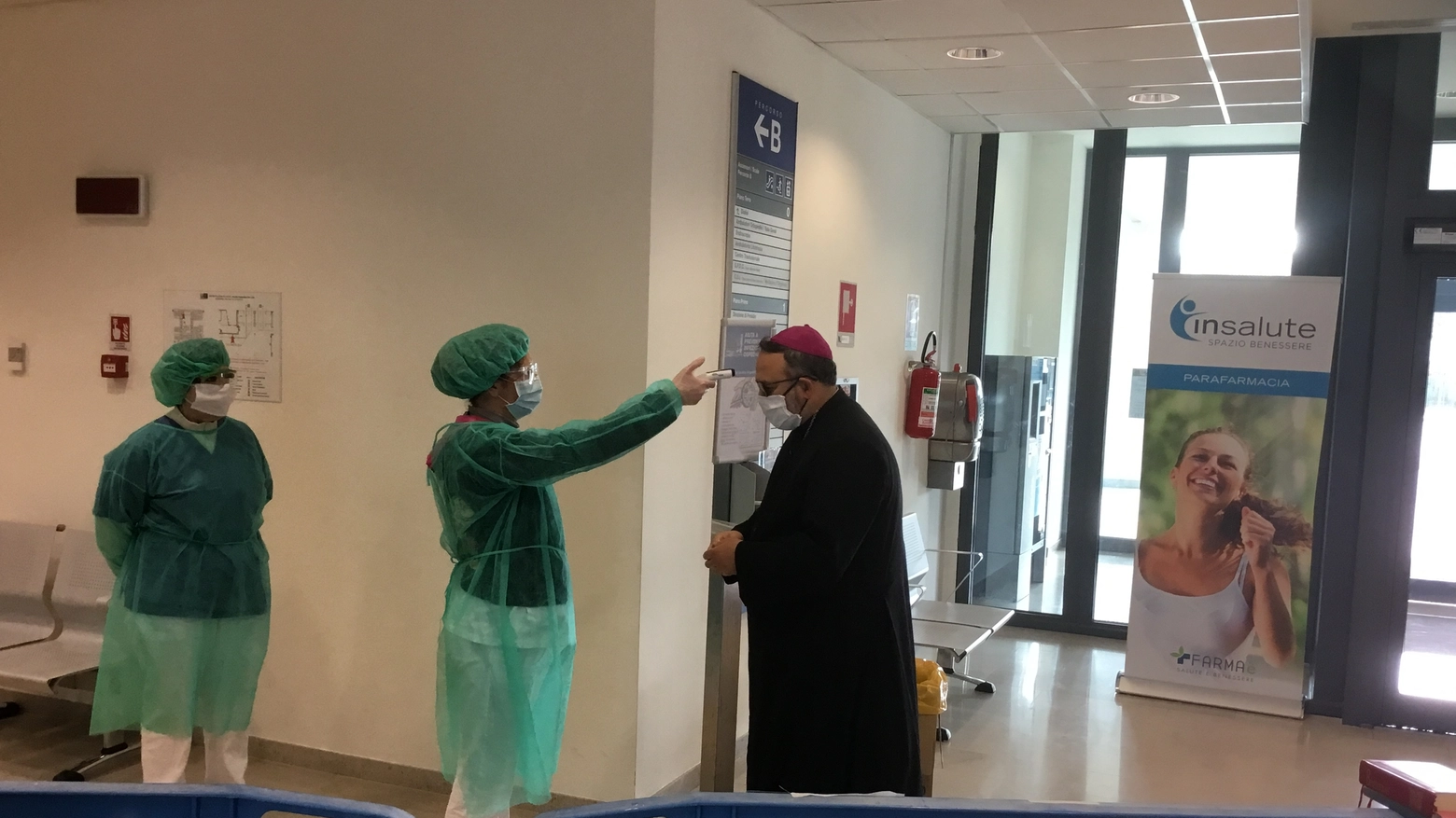 Anche a monsignor Giulietti viene misurata la temperatura prima della visita all'ospedale