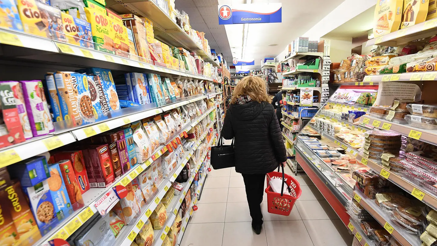 Una persona fa la spesa in un supermercato  (Ansa)
