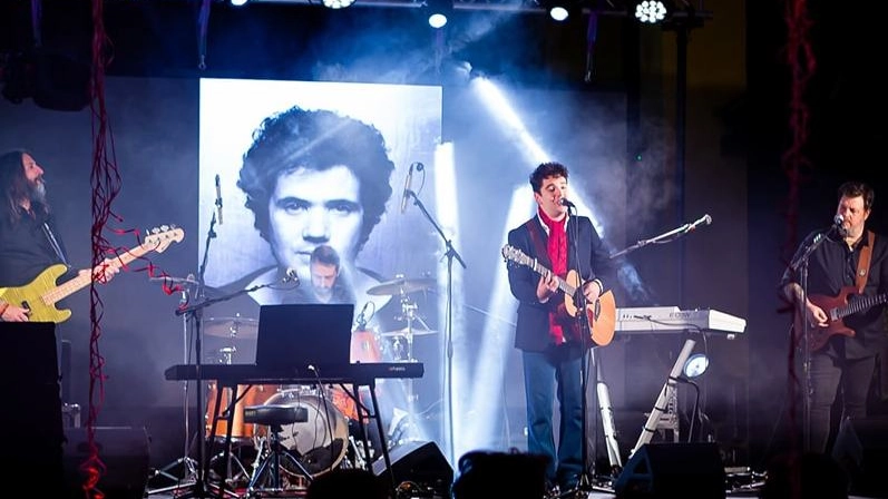 Francesco Raineri, la voce di Innocenti Evasioni, una delle cover band di Lucio Battisti più accreditate in Italia. In alto uno scatto in un concerto con la foto del cantautore scomparso all’età di 55 anni
