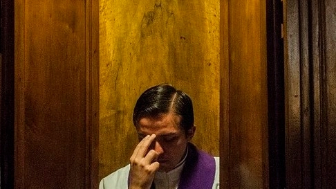 Un prete in un confessionale