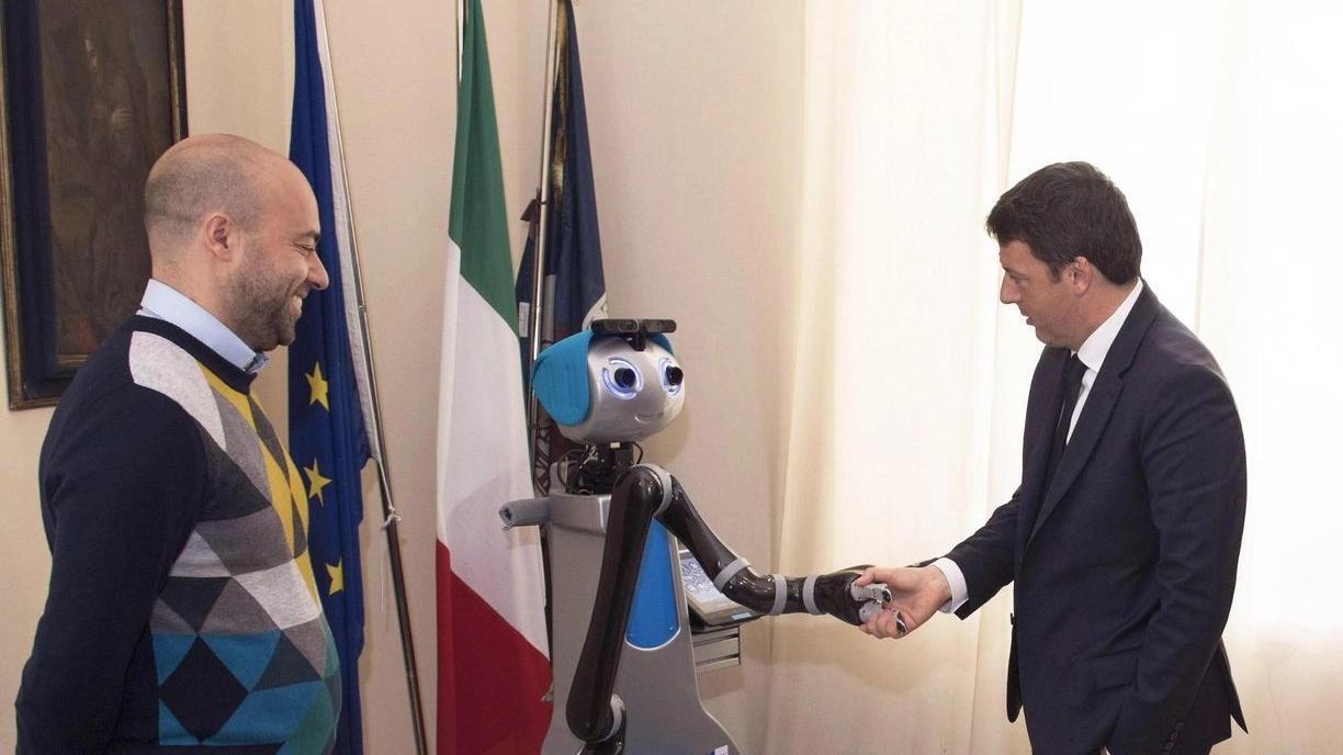 Matteo Renzi con un robot alla Scuola Superiore Sant'Anna di Pisa (Ansa)