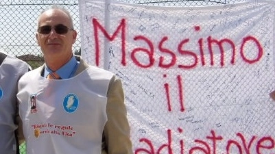 Massimiliano Massimi davanti allo striscione col nome del figlio