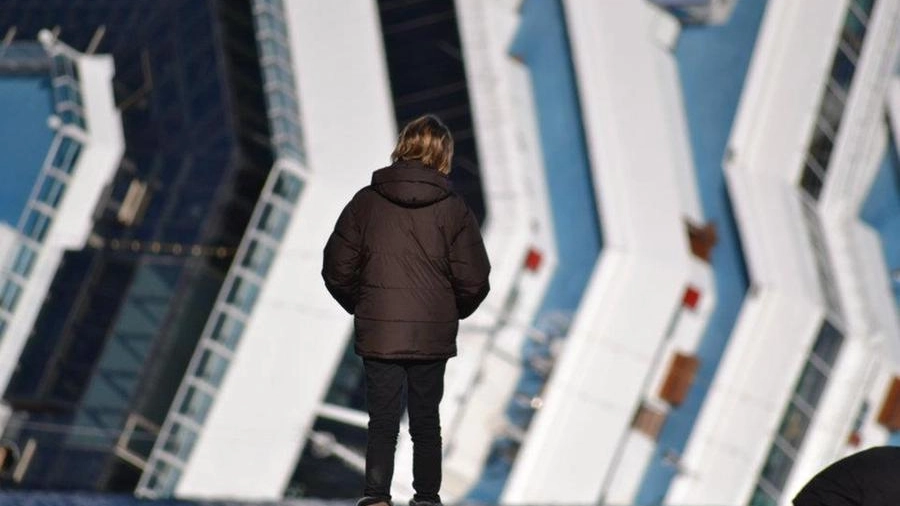 Una persona guarda il relitto della Concordia sugli scogli del Giglio (Foto F. Marinari)