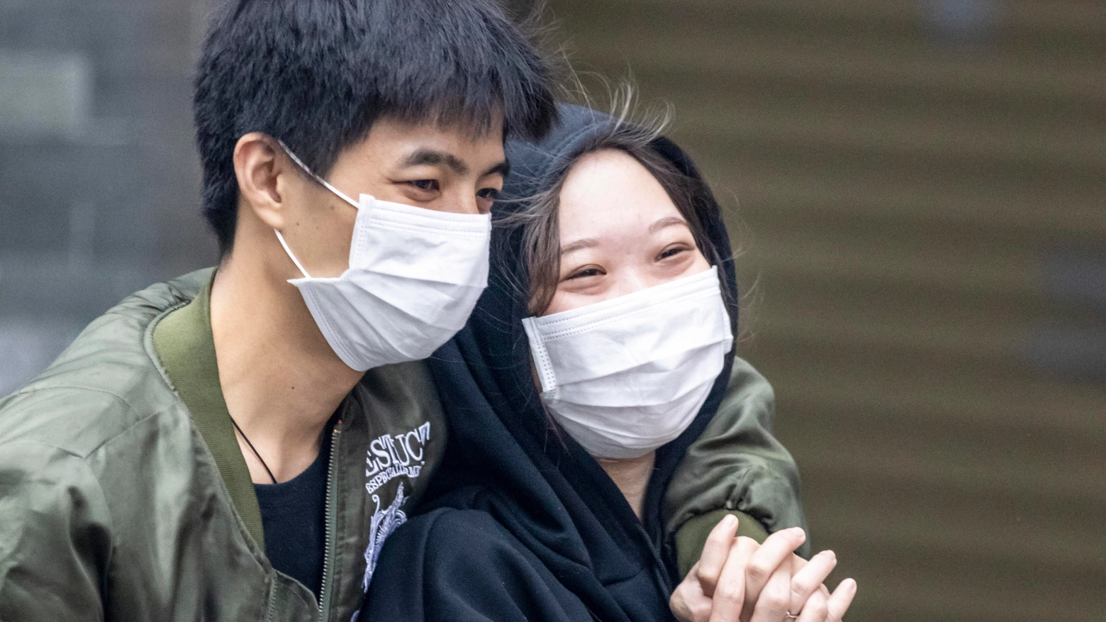Due giovani cinesi si proteggono con la mascherina 