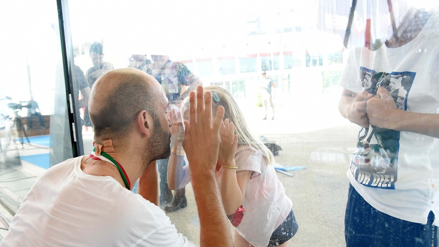 Stefano Tempesti, tricolore al collo, bacia i figli al di là del vetro (foto Alive)