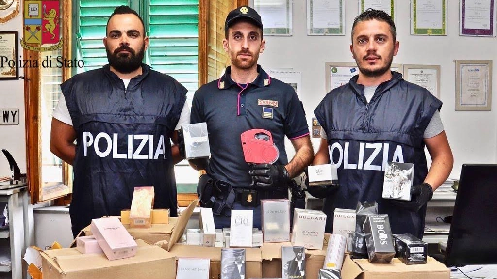 Gli agenti del commissariato mostrano i profumi contraffatti sequestrati