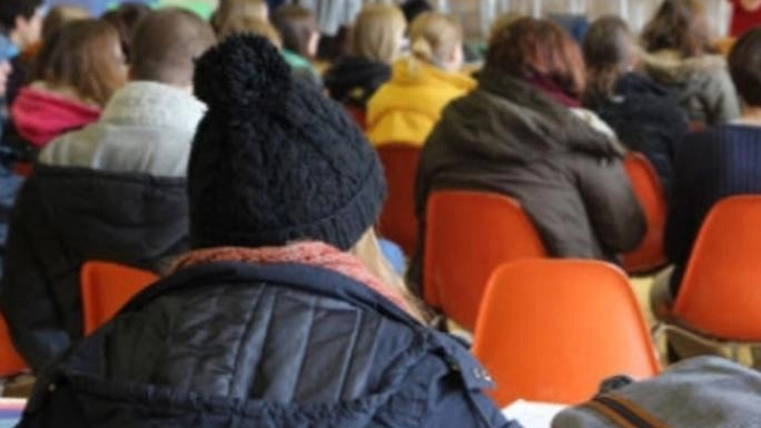 Termosifoni ghiacci. Gli studenti in classe con piumini e giubbotti Termosifoni ghiacci. Gli studenti in classe con piumini e giubbotti