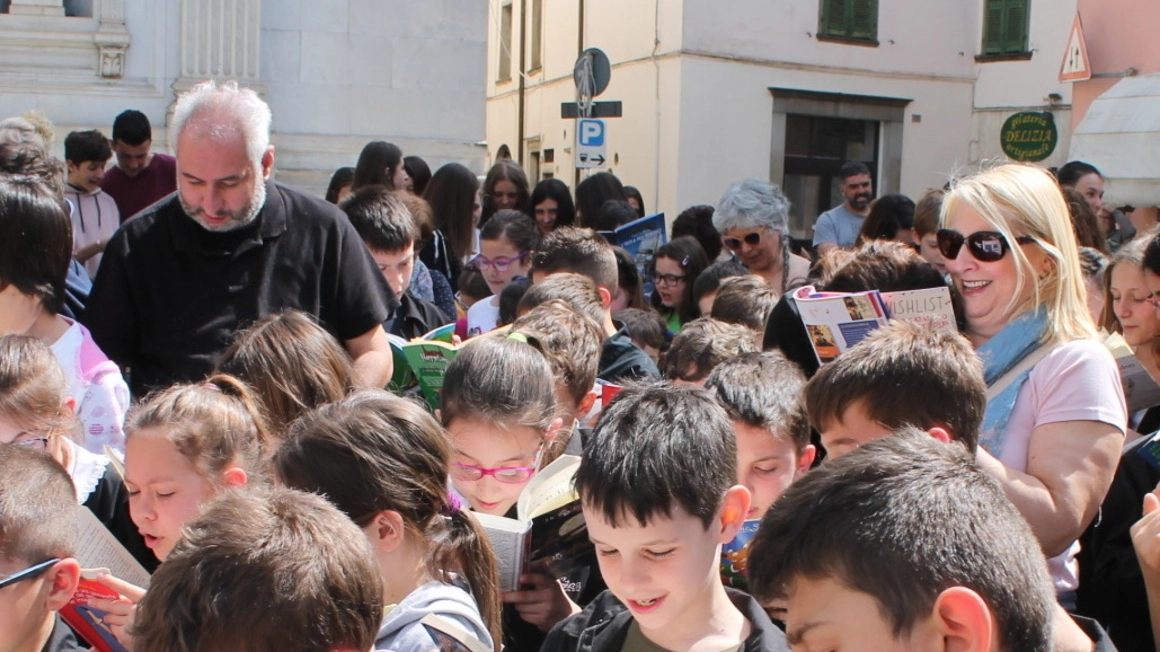  Studenti leggono passi dei libri che hanno in mano in piazza a Pontremoli