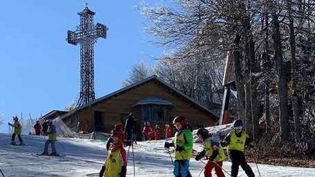 I bambini si divertono a sciare al campo scuola, a valle ci sono 5 centimetri di neve