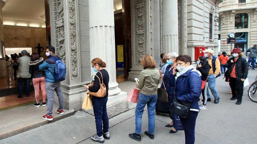 Persone in coda davanti all’ufficio postale in Cordusio per completare la procedura per lo