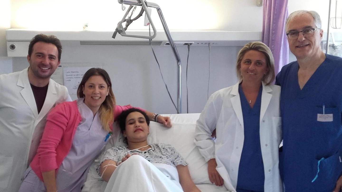 La neo-mamma con lo staff medico: tutti sorridenti  dopo il parto cesareo