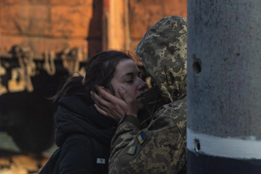 Un soldato ucraino bacia la fidanzata alla stazione (Ansa)