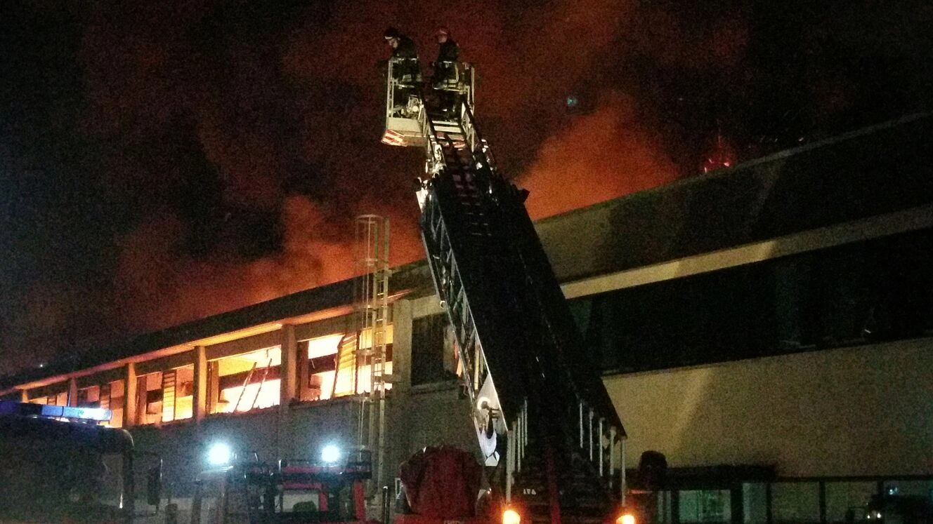 I vigili del fuoco in azione a Porcari, sull sfondo il capannone in fiamme