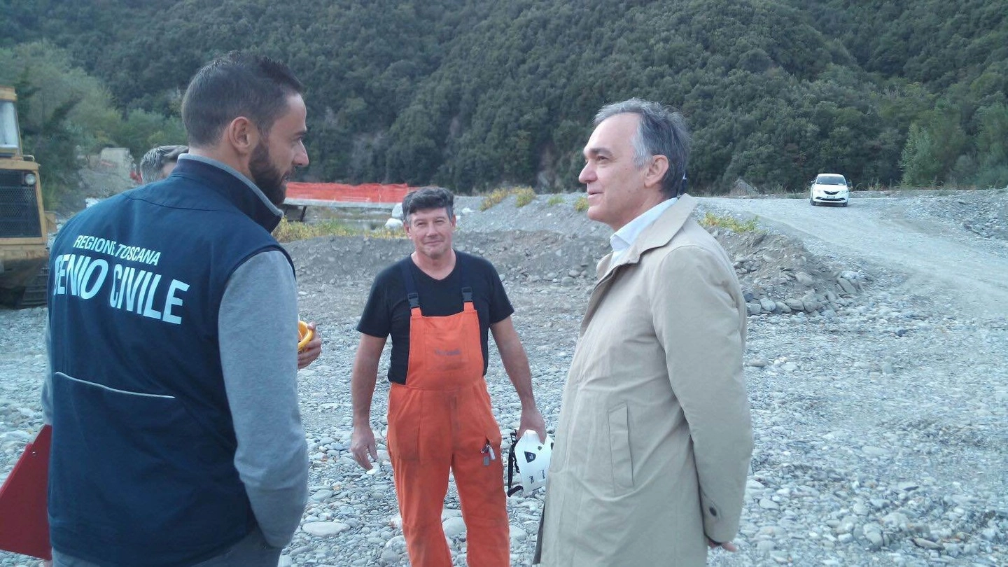 Il presidente Enrico Rossi sul greto del fiume Magra menter parla con tecnici e operai