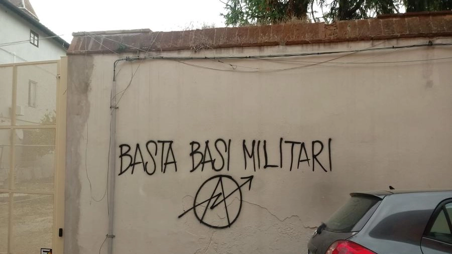 Una scritta sui muri di Pisa contro la base militare di Coltano