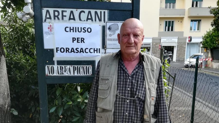 Il volontario Luca Razzolini davanti al cartello nell'area cani