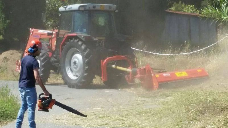 L’assessore Federico Sebastiani ripulisce una strada dopo il passaggio dell’unico mezzo disponibile per tagliare l’erba