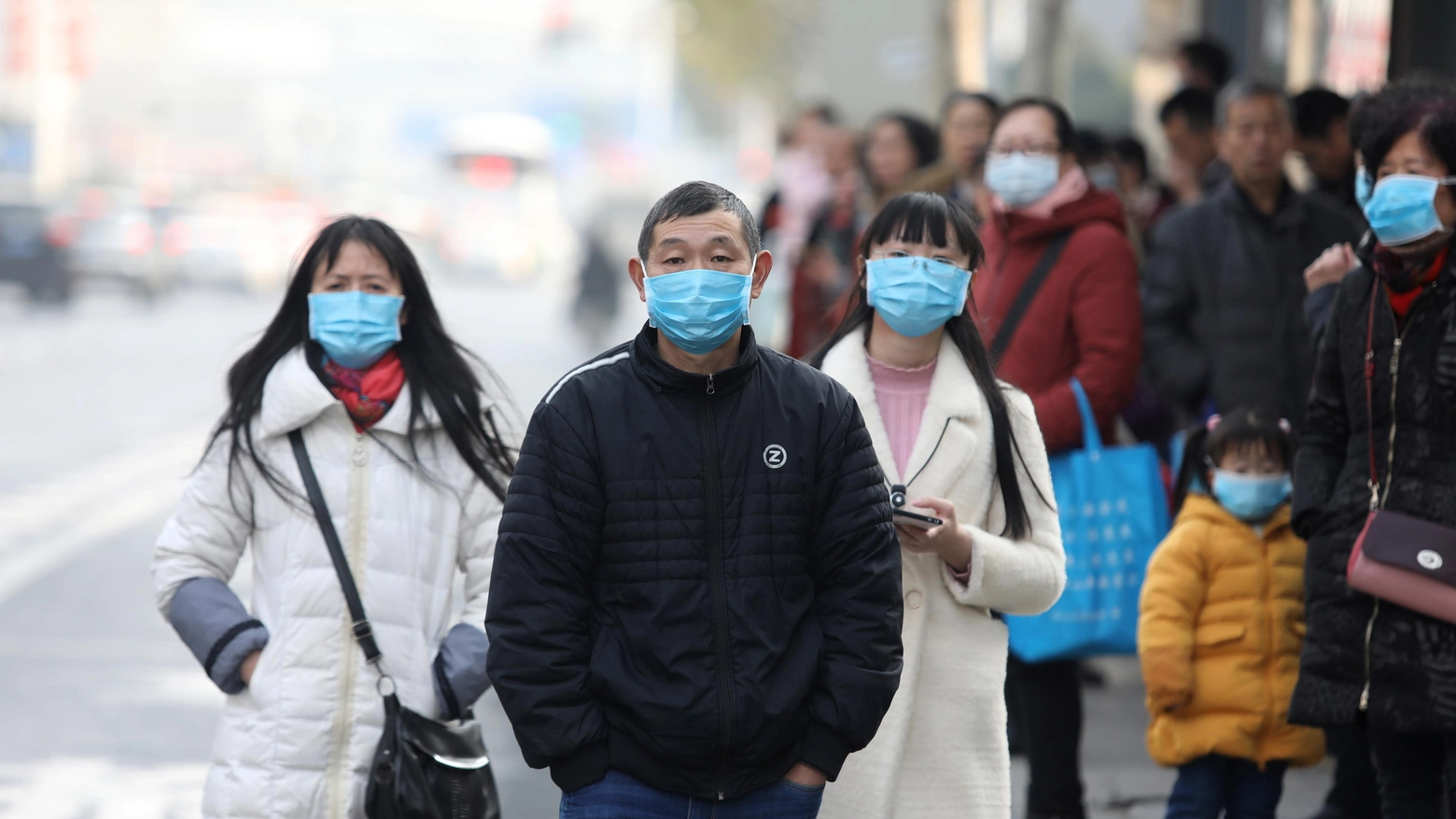 Cinesi con mascherine a Wuhan, dove si sono registrati i primi casi del virus (Ansa)