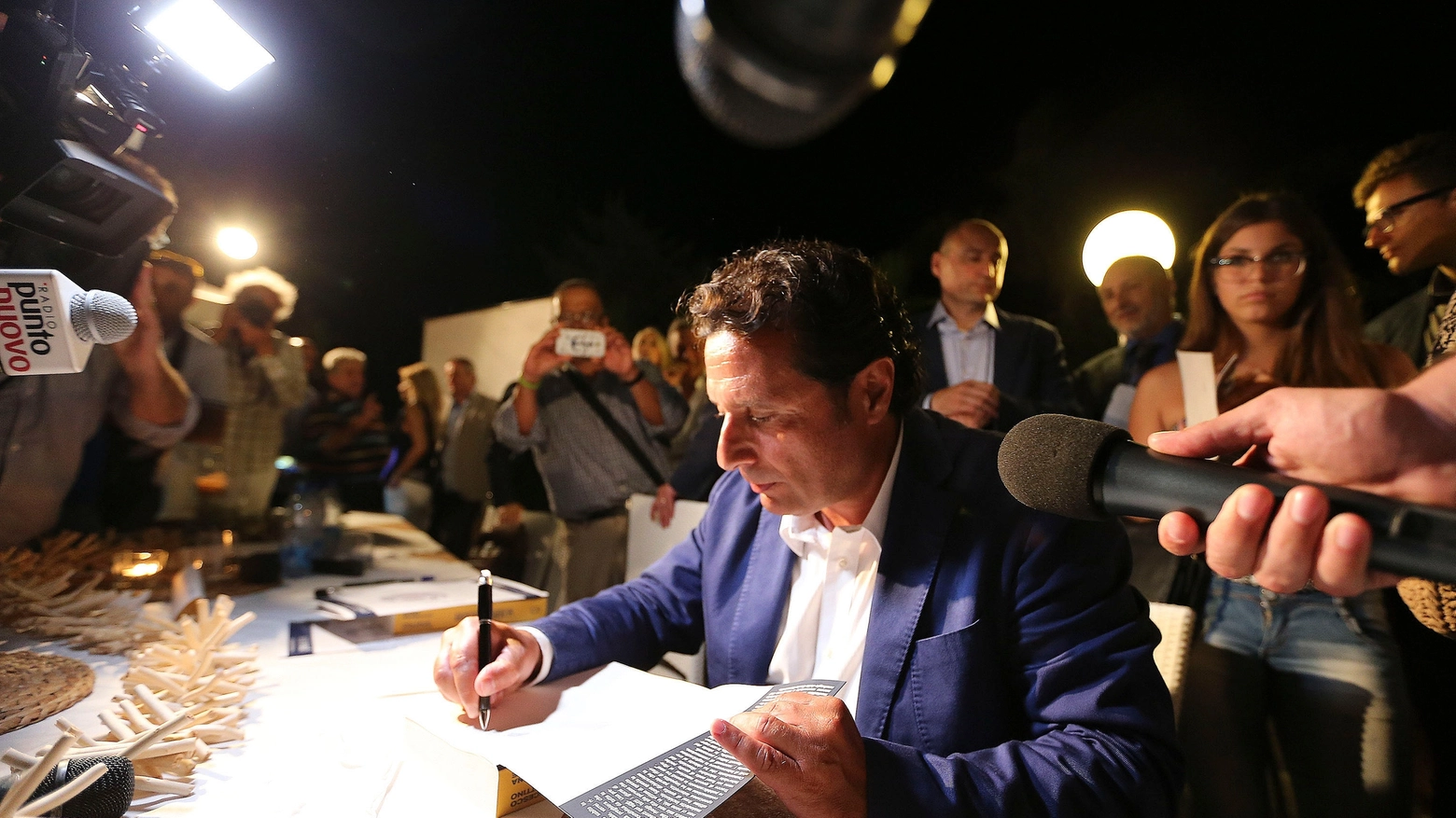 Schettino autografa il libro (foto LaPresse)